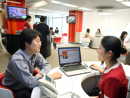 A staff member of an SK Telecom business partner is shown testing a terminal in the NATE Business Center (On April 25th SK Telecom renewed the activities of the NATE Business Center. This center is designed to support small and medium-sized business partners who develop and supply wireless Internet content and solutions to SK Telecom).